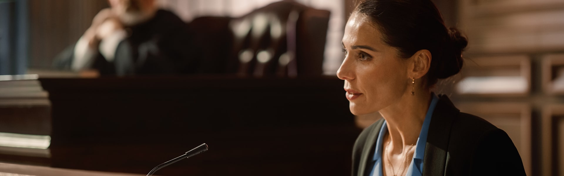 Female witness giving testimony in courtroom during legal proceedings.