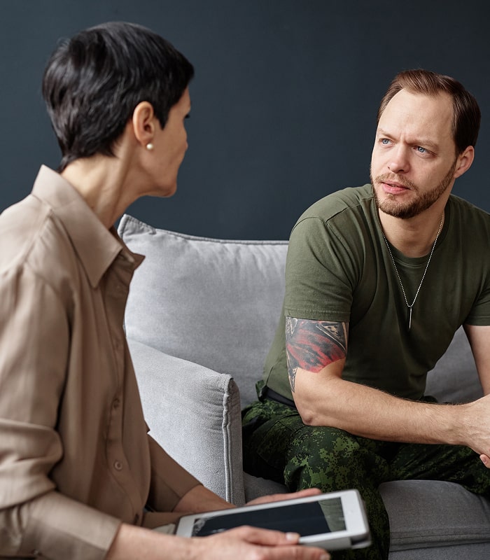Psychiatrist speaking with male patient during a counseling session.