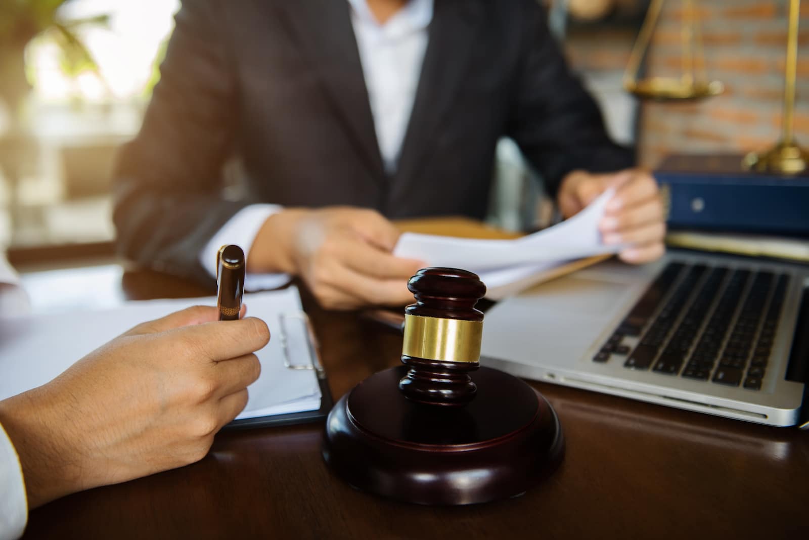 Forensic psychiatry expert reviewing legal documents and IMEs at a desk with a gavel and laptop for court cases in Dallas and Arlington, TX