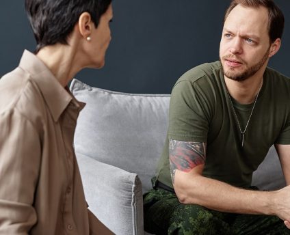 our-approach Psychiatrist speaking with male patient during a counseling session.